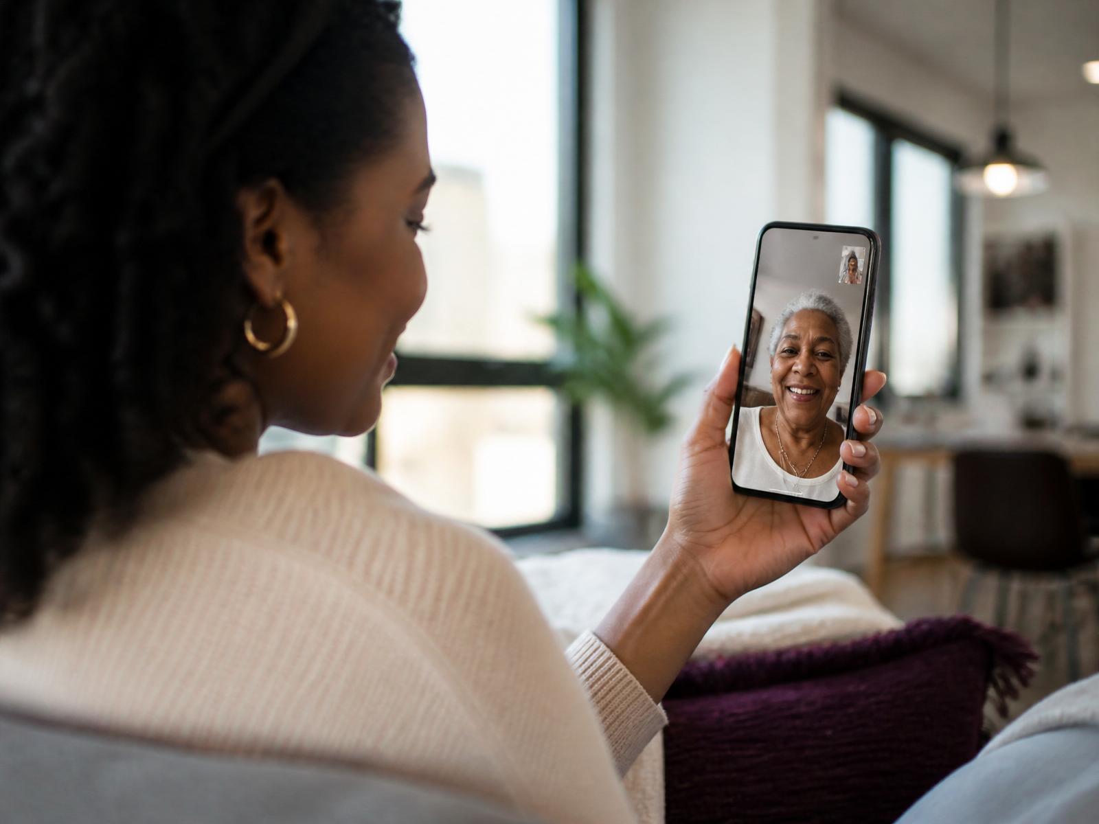 Adult daughter having a video call with her elderly mother